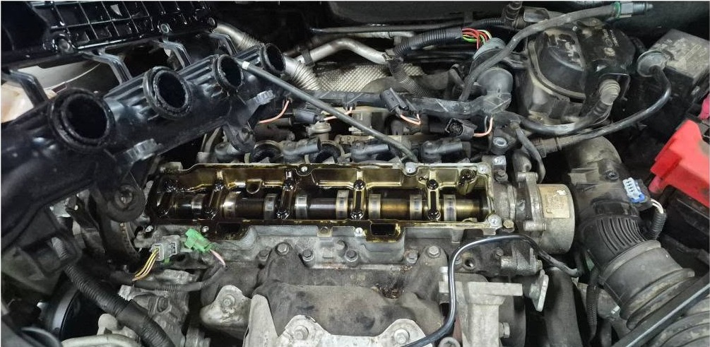 An engine with the cam cover removed in the workshop